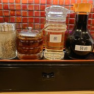 テーブルには醤油と酢、辣油、粗挽きコショウが備えられています