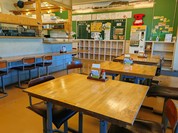 クッション付きの小学校の児童の椅子に座って給食を食べるレストラン。