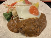 ハンバーグに目玉焼きが乗りカレーがかかってます！