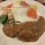 ハンバーグに目玉焼きが乗りカレーがかかってます！
