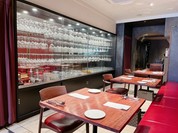 ずらりと並べられたワイングラスとカラーと重厚なワインカラーのソファーがお洒落です