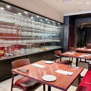 ずらりと並べられたワイングラスとカラーと重厚なワインカラーのソファーがお洒落です